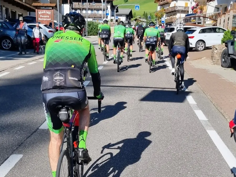 Groep WVLR-renners van achteren onderweg door een bergdorp